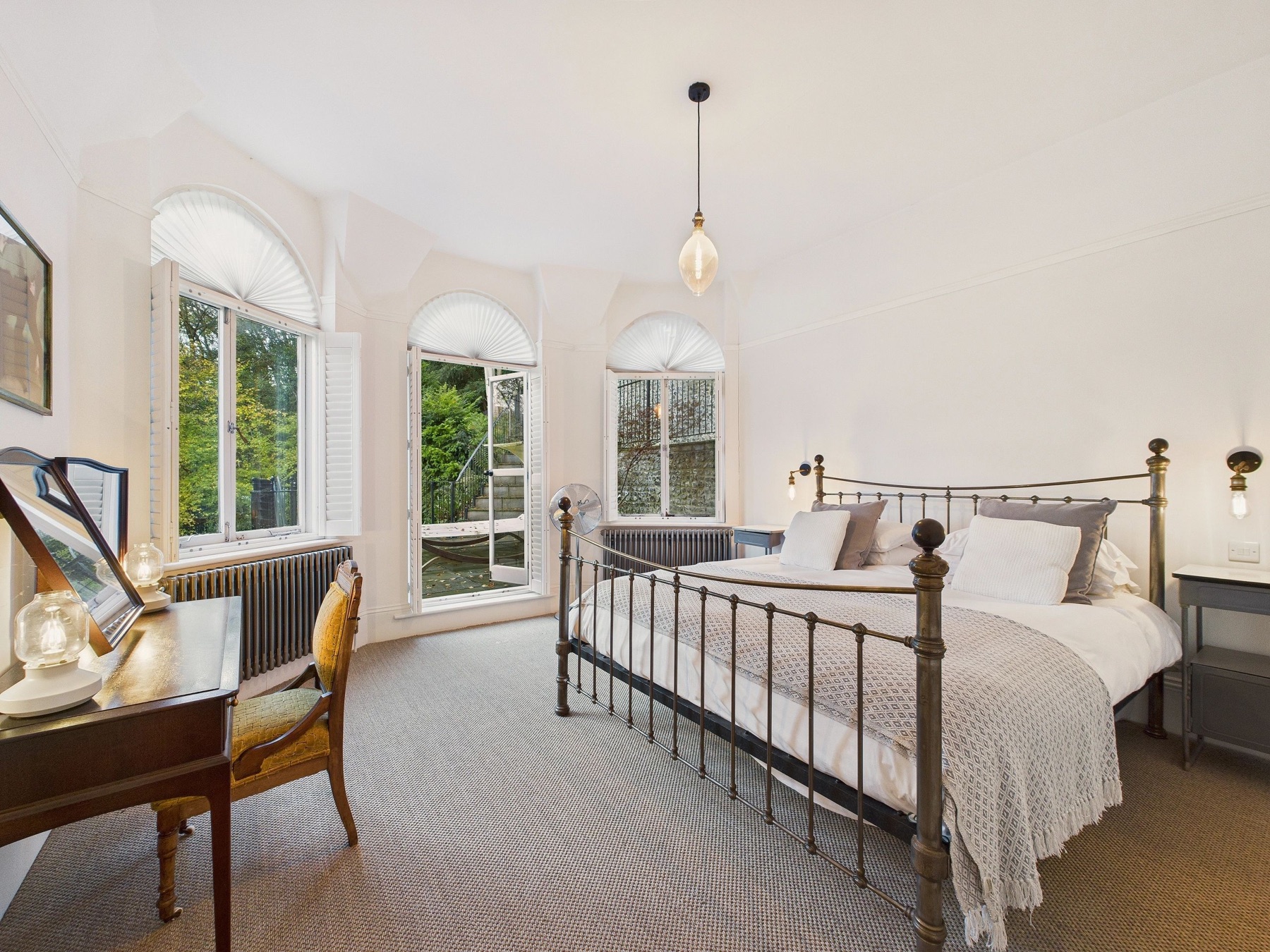 Bright bedroom with arched windows at Undercliffe House